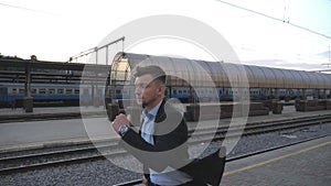Successful businessman running through railway station and looking at watch. Young man is late for train. Business