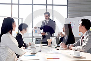 Successful businessman sharing experience success and giving presentation at conference meeting desk, five businesspeople having