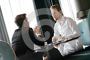 Successful businessman smiling while discussing with partner during meeting at coffee break
