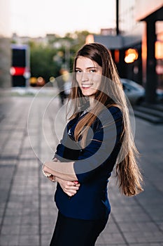 Successful businessman smiling, standing on the background of buildings and holding a tablet computer. City business woman working