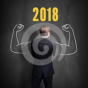 Successful businessman standing in front of a blackboard