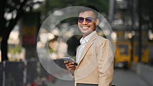 Successful businessman in stylish suit standing outdoor with cityscape background in early morning