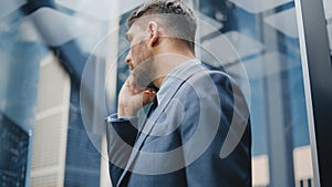 Successful Businessman in a Suit Riding Glass Elevator to Office in Modern Business Center. Handso