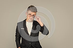 successful businessman. trendy looking teenager. child in black jacket. confident kid boy wear glasses.