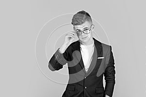 successful businessman. trendy looking teenager. child in black jacket. confident kid boy wear glasses.