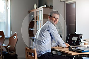 Successful businessman at work on a laptop in an office