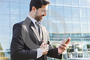 Successful businessman or worker standing in suit with cellphone