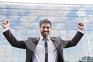 Successful businessman or worker standing in suit near office building