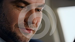 Successful businessman working jet closeup. Cheerful bearded man looking window