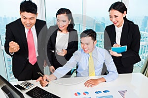 Successful businesspeople looking at computer