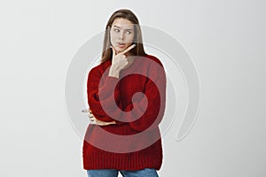 Successful businesswoman deciding how to escape awkward situation. Shot of serious gorgeous european woman in red loose
