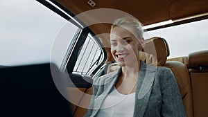 Successful businesswoman enjoying success in car. Business woman looking laptop