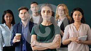 Successful businesswoman posing with multiracial colleagues in office