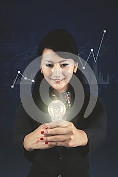 Successful businesswoman showing a bright bulb