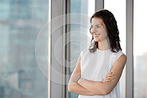 Successful businesswoman standing in office looking at window