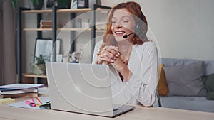 Successful Caucasian woman in headset with mic talks and gestures with hands.