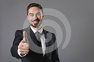 Successful cheerful bearded man giving thumbs up