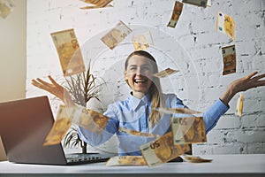 Successful business woman throwing euro banknotes in office. falling money