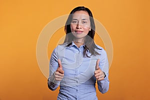 Successful cheerful woman doing thumbs up gesture