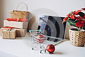 Successful Christmas Season in E-Commerce, Christmas online shopping. Open laptop computer Display screen, mini shopping