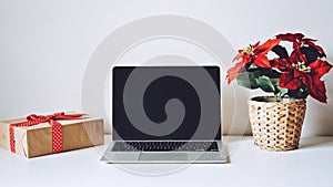 Successful Christmas Season in E-Commerce, Christmas online shopping. Open laptop computer Display screen, Poinsettias