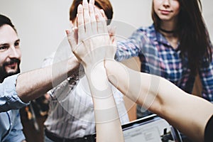 Successful and cohesive team of people make High Five photo