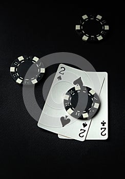 A successful combination of cards one pair and chips in a casino on a black table. Winning in the game of poker depends on luck