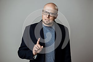 Successful confident businessman in glasses speaking over beige background.