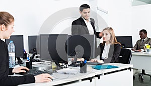 Successful coworkers engaged in business activities in busy open plan office