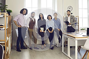 Successful creative professional business team standing by window in modern office