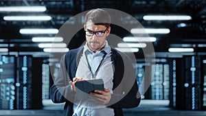 Successful Data Center IT Specialist Using Tablet Computer. Server Farm Cloud Computing Facility
