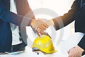 Successful deal, male architect shaking hands with client in construction site.