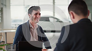 successful deal, portrait of happy male customer talking to sales manager in vehicle about new car and shaking hands in