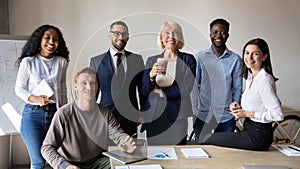 Successful diverse employees with team leader looking at camera