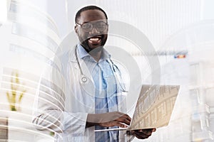 Successful doctor keeping a laptop in hands