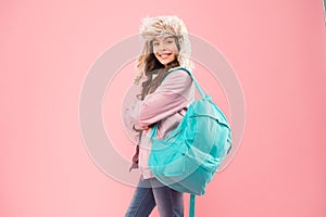 Successful Everyday. kid warm clothes pink background. happy child earflap hat. schoolgirl with backpack. end of school