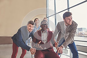 Successful excited Business people group team push colleague sitting in chair