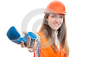 Successful female constructor giving the phone receiver