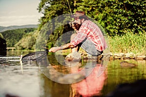 successful fisherman in lake water. big game fishing. relax on nature. hipster fishing with spoon-bait. mature bearded