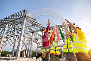 Successful fo Architect and Engineer construction workers join hands while working at outdoors construction site. Building