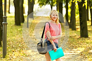 Successful girl student with books in the Park