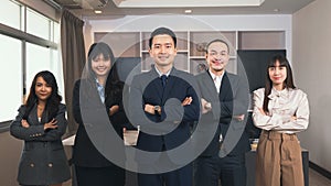 Successful group of business people smiling while standing with crossed arms in office