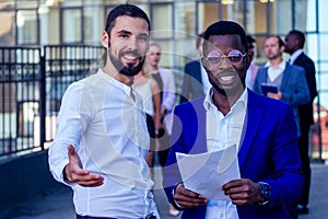 Successful and handsome African American man in a stylish business suit giving a hand for a handshake sign welcome ahead