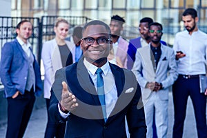 Successful and handsome African American man in a stylish business suit giving a hand for a handshake sign welcome ahead