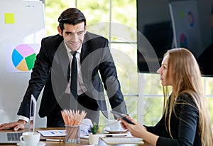 Successful handsome young adult caucasian businessman leader standing in front of the multiracial meeting looking at the caucasian