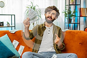 Successful happy rich business man counting money cheering up with high profits, lottery game win