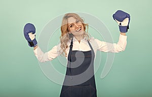 successful happy woman in cook apron and boxing gloves, housewife