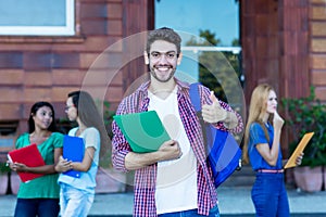 Successful hipster male student with group of young adults