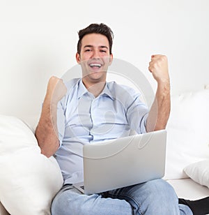 Successful hispanic guy with notebook on a sofa