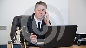 Successful lawyer taking a phone call at his office. Speak phone with client and trying to explain the things.